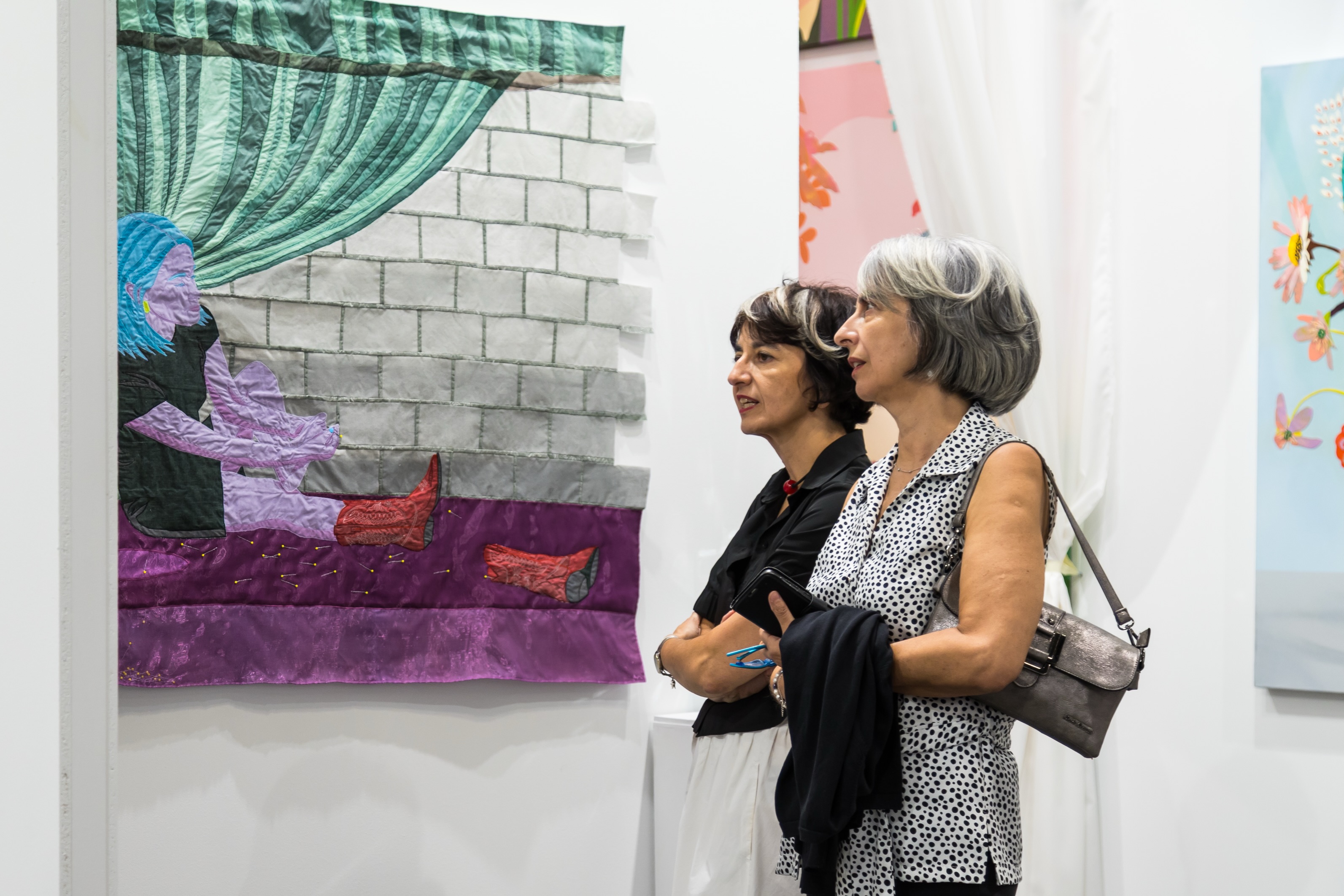 Visitantes junto a una obra de Lauren Januhowski en Estampa 2026